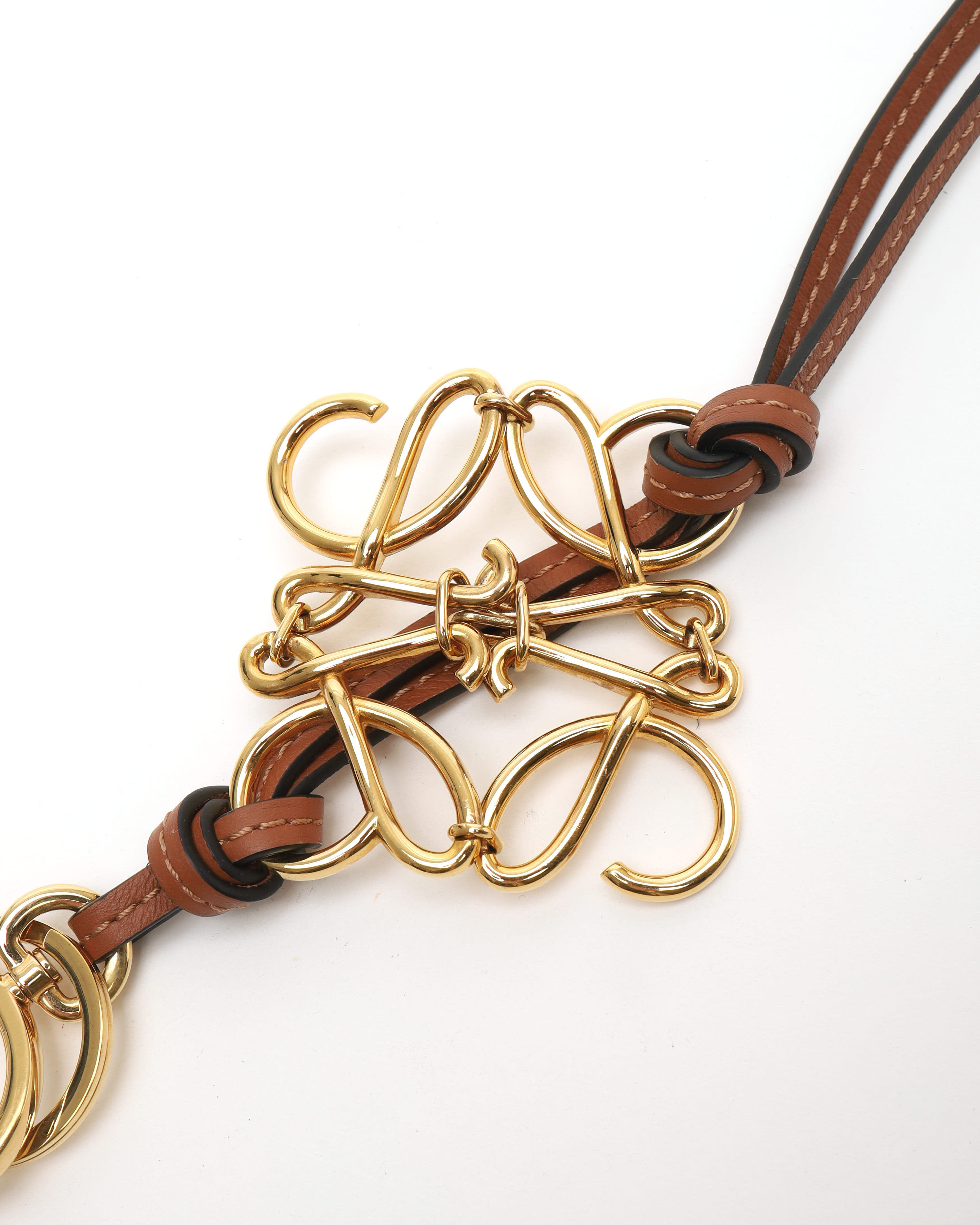 Loewe Anagram Charm In A Gold Finish On A Calfskin Strap In Gold